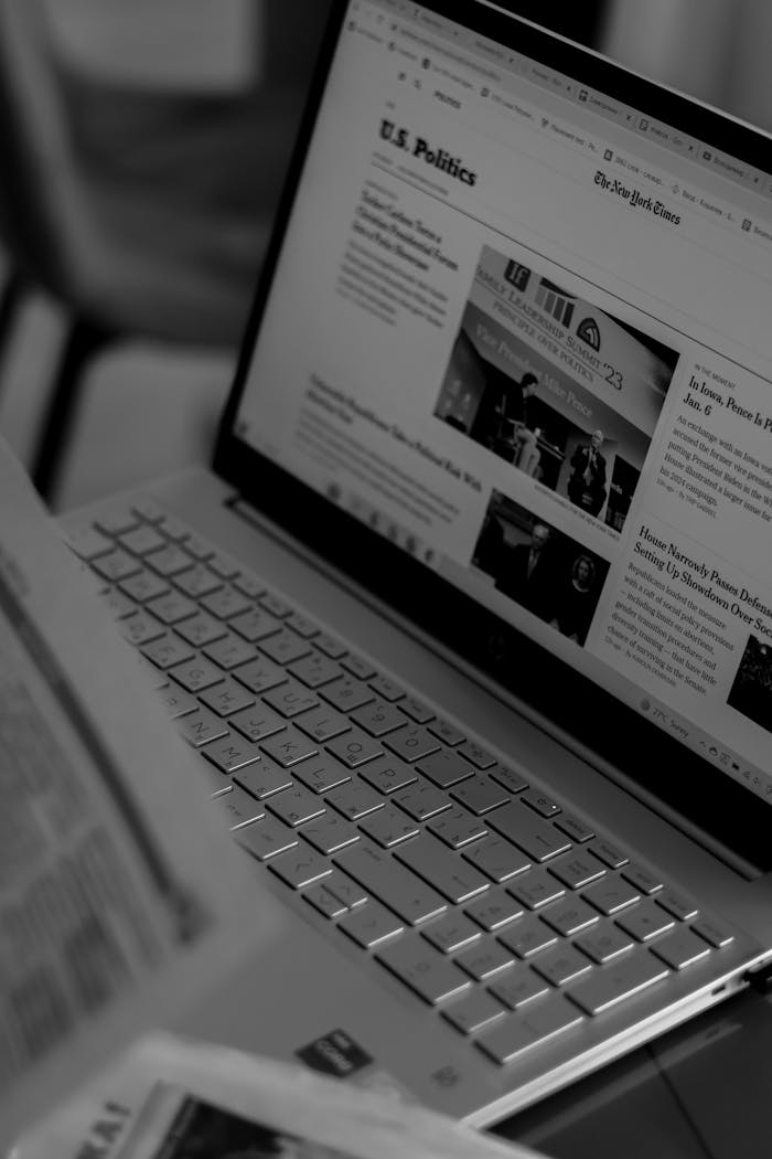 Black and white photo of a laptop showing a news website with focus on U.S. politics section.